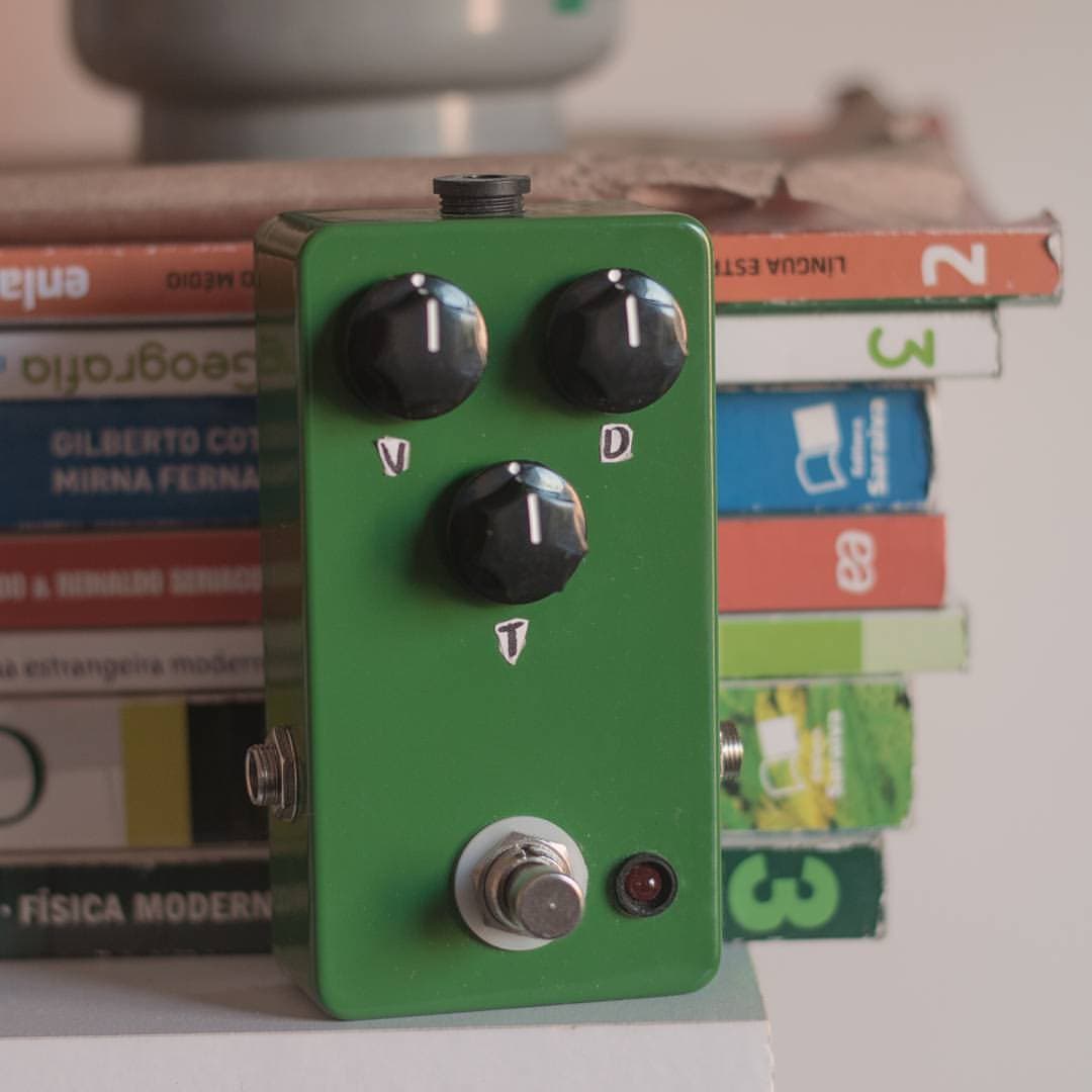 Pedal verde montado à mão por Ítalo, apoiado em livros escolares