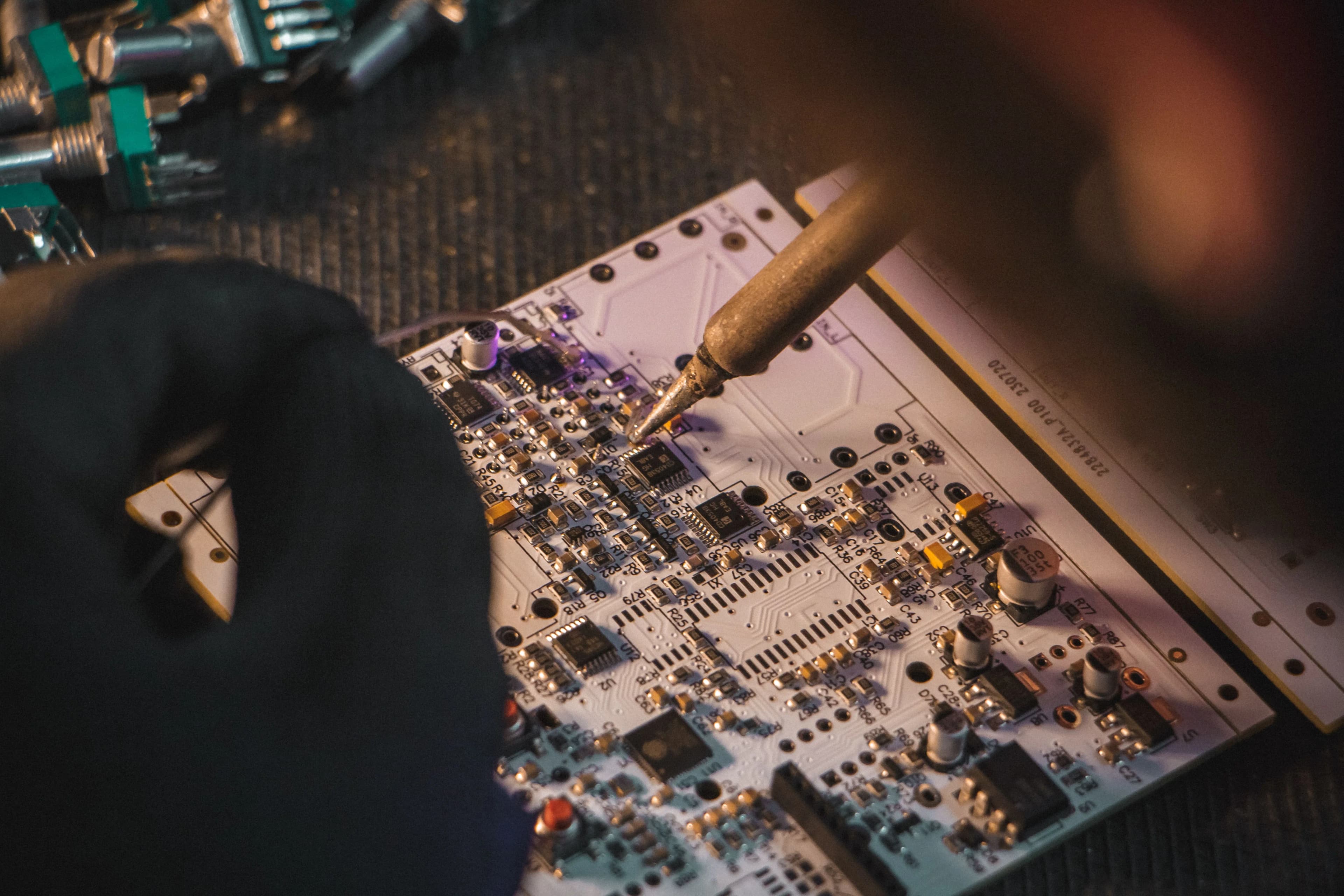 Placa de circuito de um pedal VTR sendo soldada à mão na produção