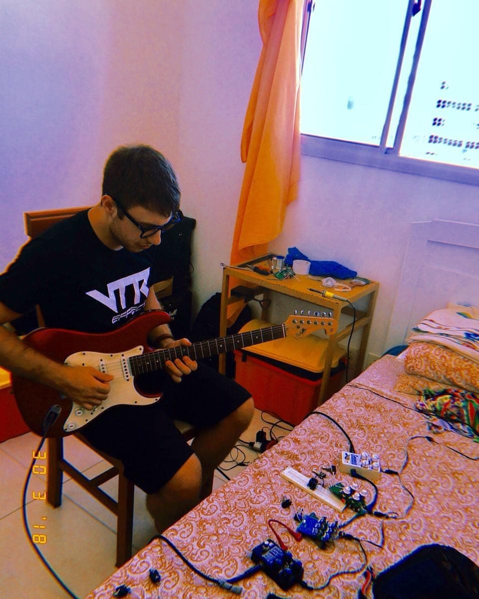 Ítalo Frota testando pedais com a guitarra no quarto